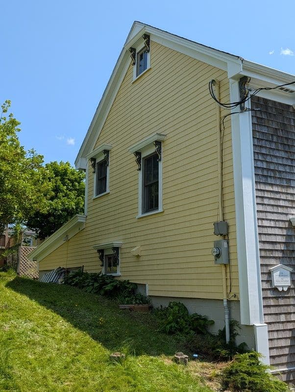 A freshly painted yellow house on a bright blue sky day