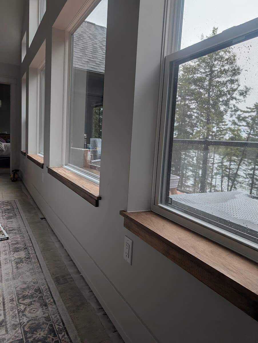 Inside view of new wood trim on a window with a view of trees outside