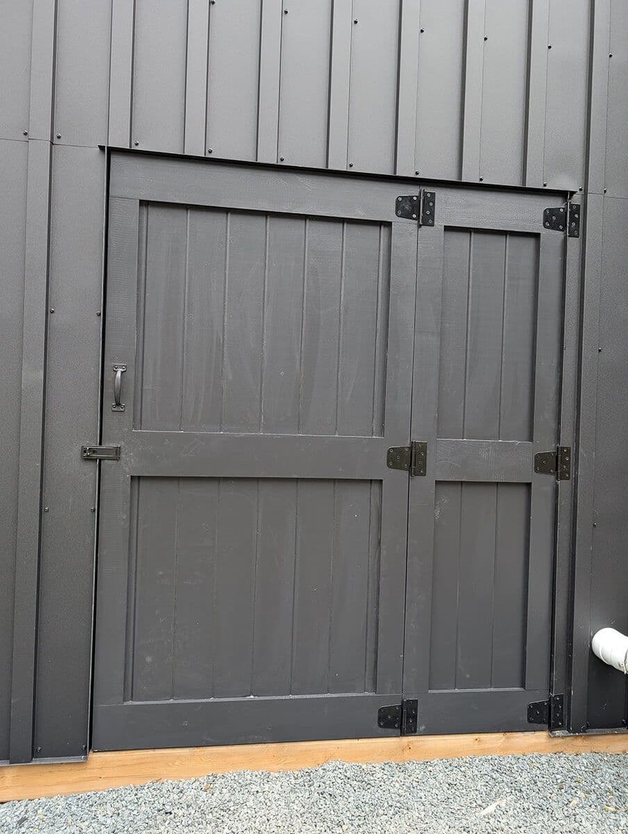 A freshly painted, outside, black door